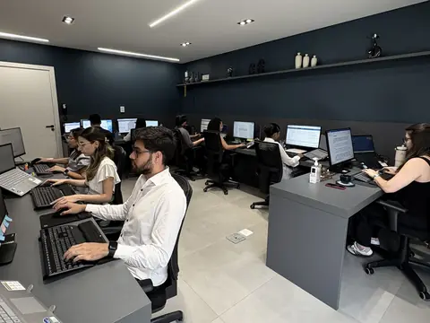 Salão de trabalho da sede, com a equipe nas estações de trabalho